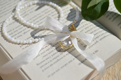 Helmikaulakoru kullatulla lasiriipuksella. 