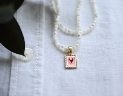 Helmikaulakoru kullatulla sydänriipuksella.