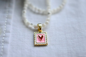 Helmikaulakoru kullatulla sydänriipuksella.