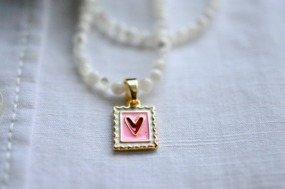 Helmikaulakoru kullatulla sydänriipuksella.