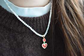 Helmikaulakoru kullatulla sydänriipuksella.