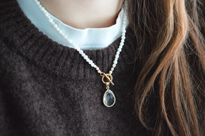 Helmikaulakoru kullatulla lasiriipuksella. 