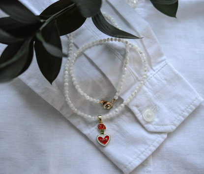 Helmikaulakoru kullatulla sydänriipuksella.