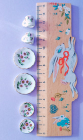 Kukkakuviolliset astiat nukkekotiin.