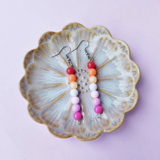 Pride helmikorvakorut, lesbo-lipun väreissä. 